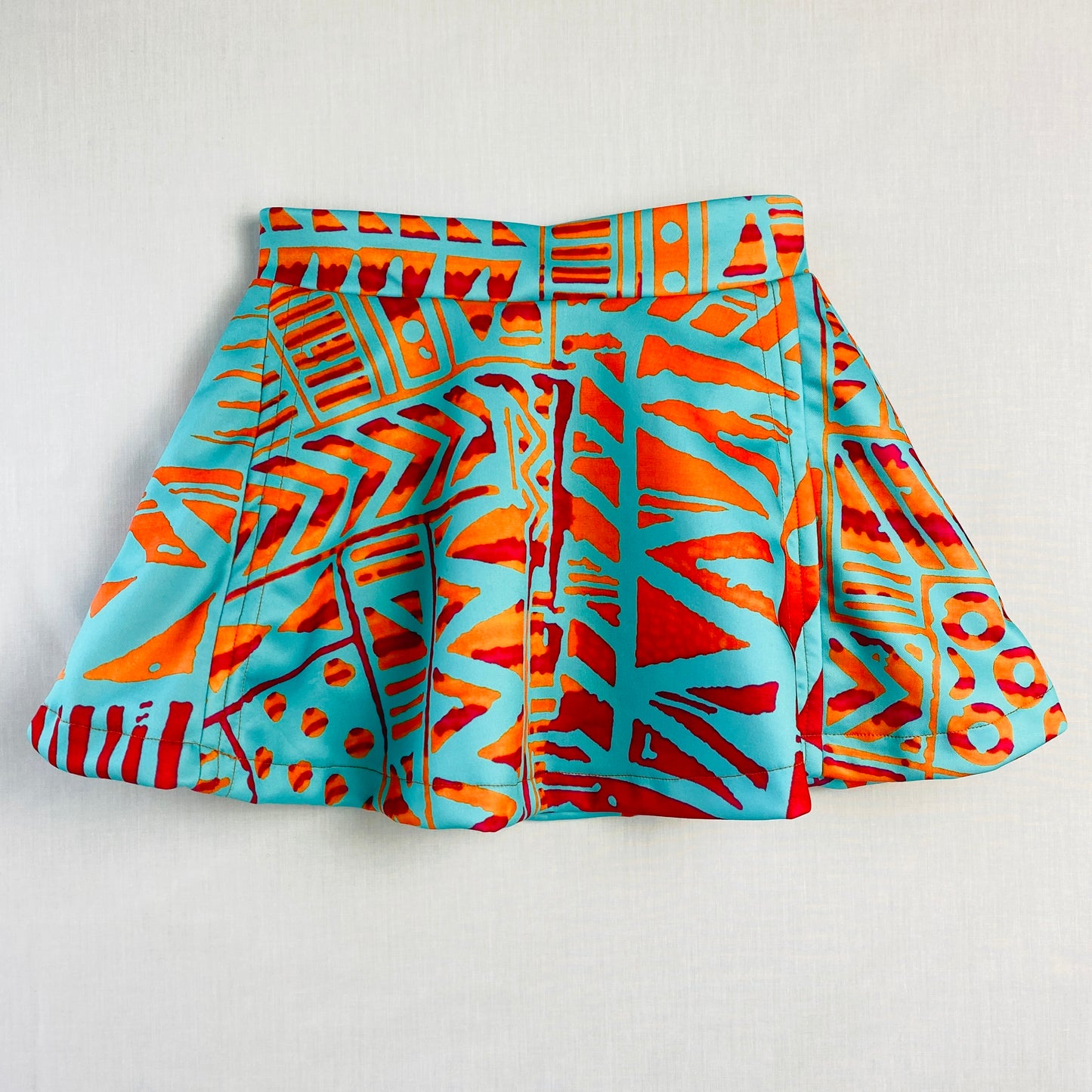 Teen Pickleball Skort (Ages 10–14)
Made from soft, stretchy polyester & spandex for comfort and movement.

Bright turquoise and orange geometric skort with black built-in shorts underneath for coverage and confidence during play.

Perfect for pickleball, tennis, school sports, dance, and everyday wear.