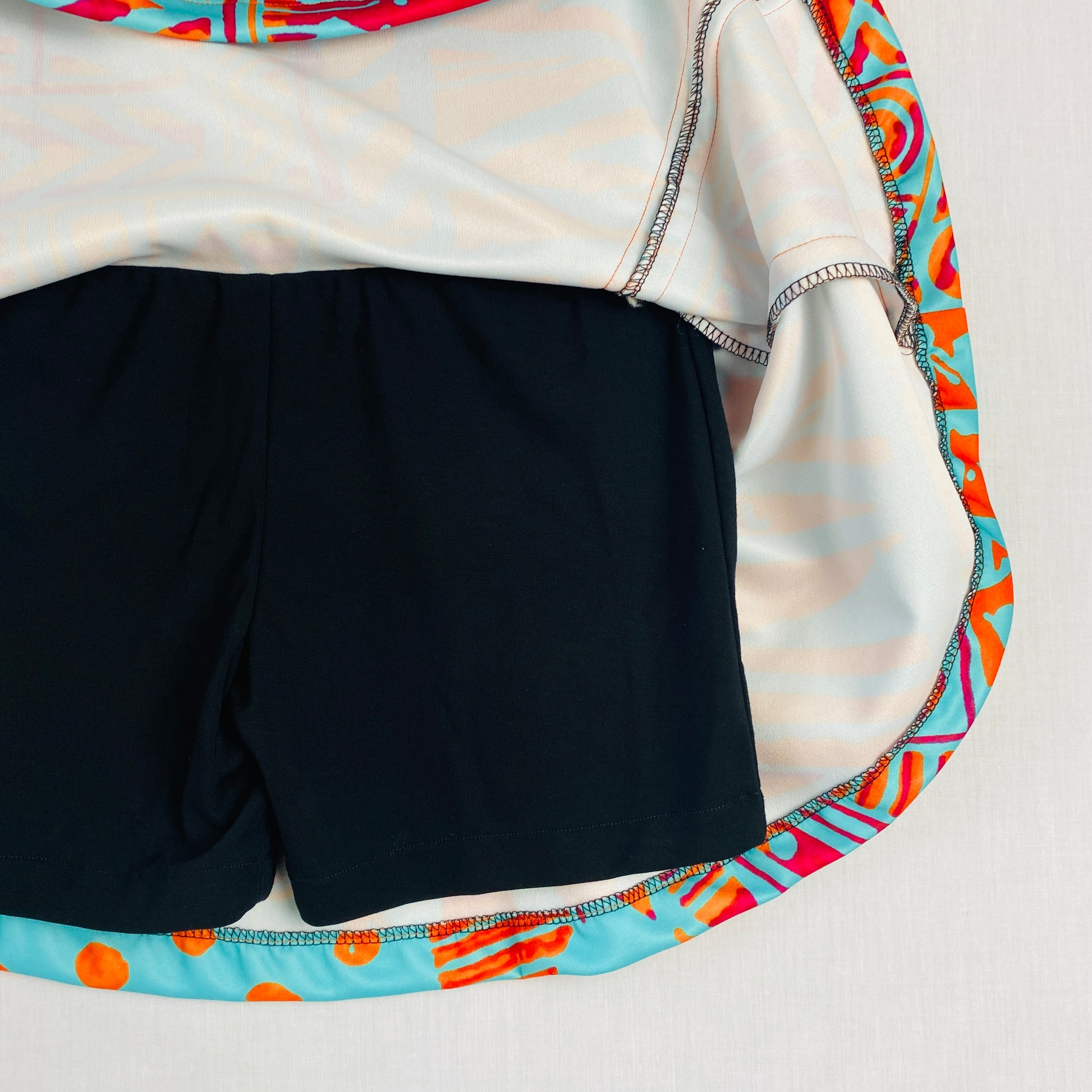 Teen Pickleball Skort (Ages 10–14)
Made from soft, stretchy polyester & spandex for comfort and movement.

Bright turquoise and orange geometric skort with black built-in shorts underneath for coverage and confidence during play.

Perfect for pickleball, tennis, school sports, dance, and everyday wear.